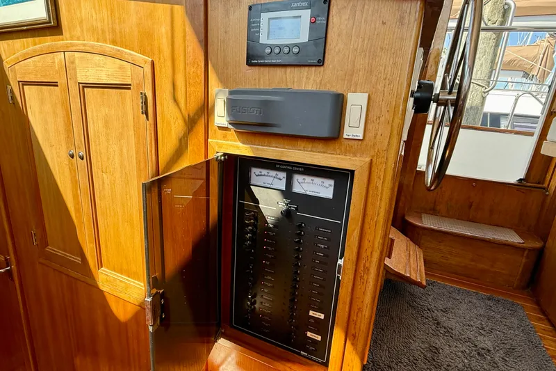 Slide: The Image of 1997 Sabre Sabreline 47 yacht interior with control panel and wooden cabinetry. - 52