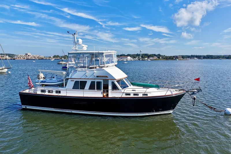 Slide: The Image of 1997 Sabre Sabreline 47 yacht anchored on a calm, scenic waterway. - 7