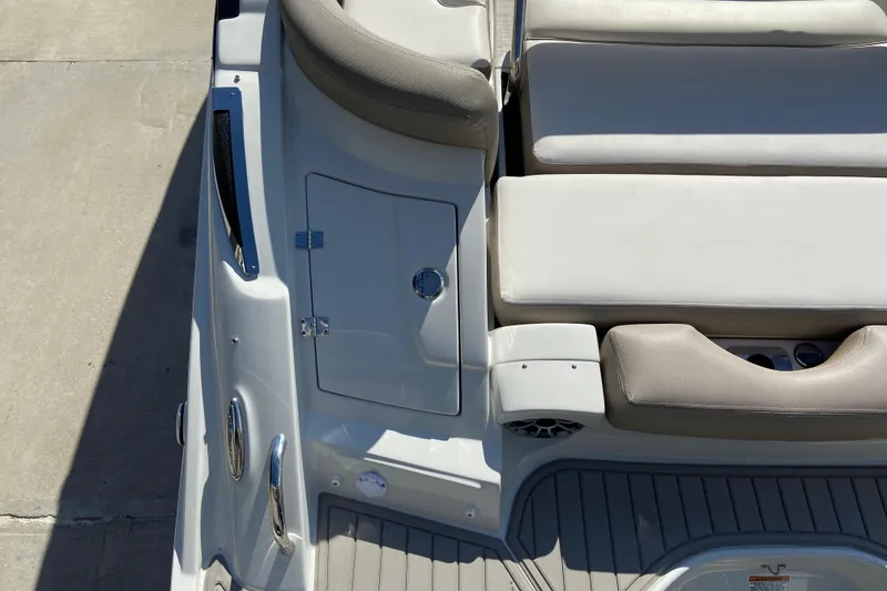 Slide: The Image of 2021 Crownline Eclipse E235 XS boat interior with cushioned seating and storage compartment. - 9