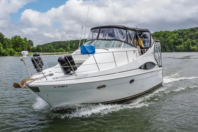 Slide: The Image of 2002 Carver 350 Mariner cruising on a scenic lake under cloudy skies. - 5
