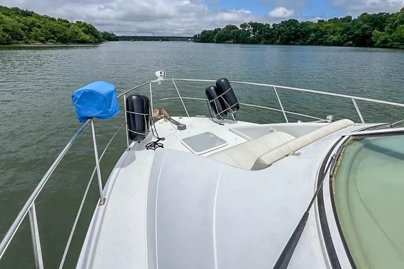 Slide: The Image of 2002 Carver 350 Mariner cruising on a scenic river under cloudy skies. - 9