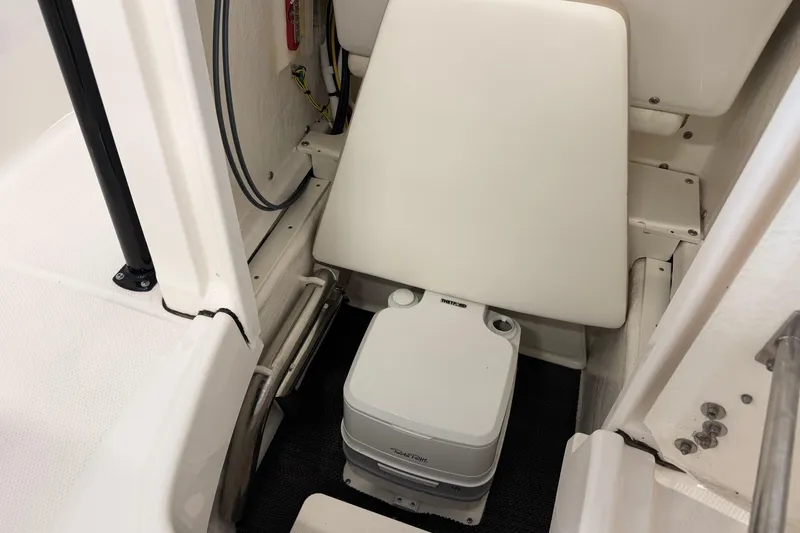 Slide: The Image of 2024 Robalo R202 Explorer boat interior with portable toilet and seating area. - 20
