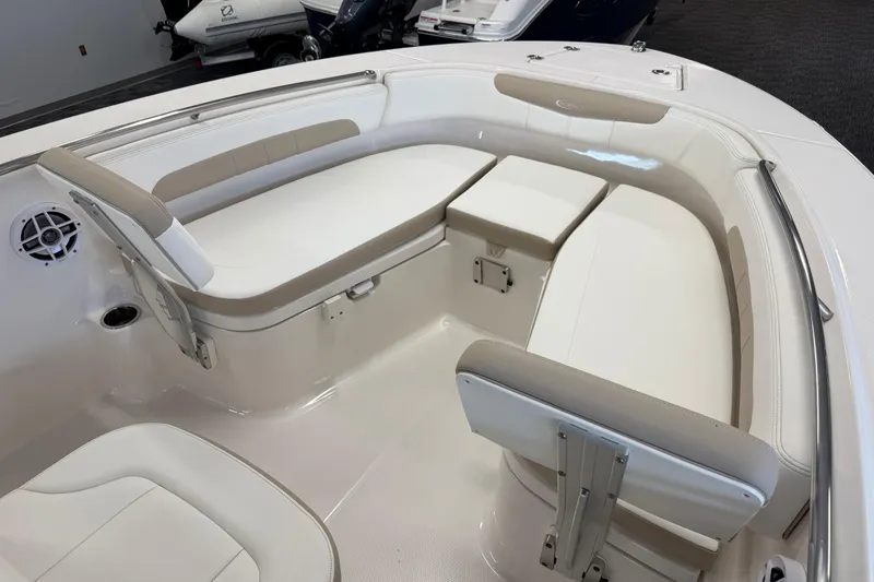 Slide: The Image of 2024 Robalo R202 Explorer boat interior with cushioned seating and storage compartments. - 21