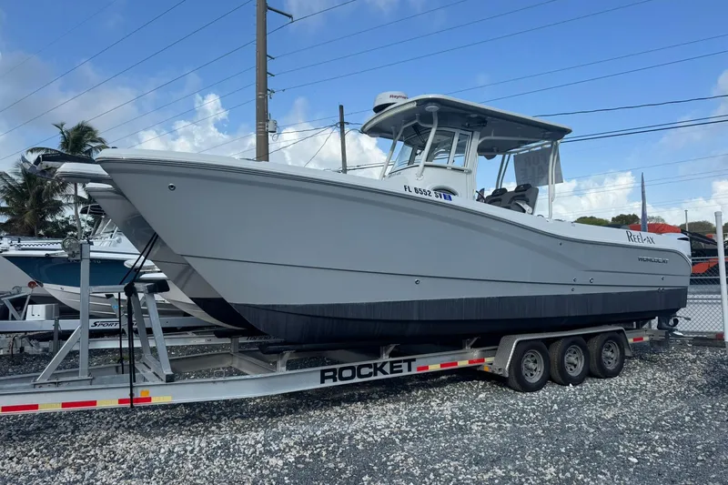 The Image of 2019 World Cat 295 CC boat on trailer, parked outdoors under blue sky. - 0