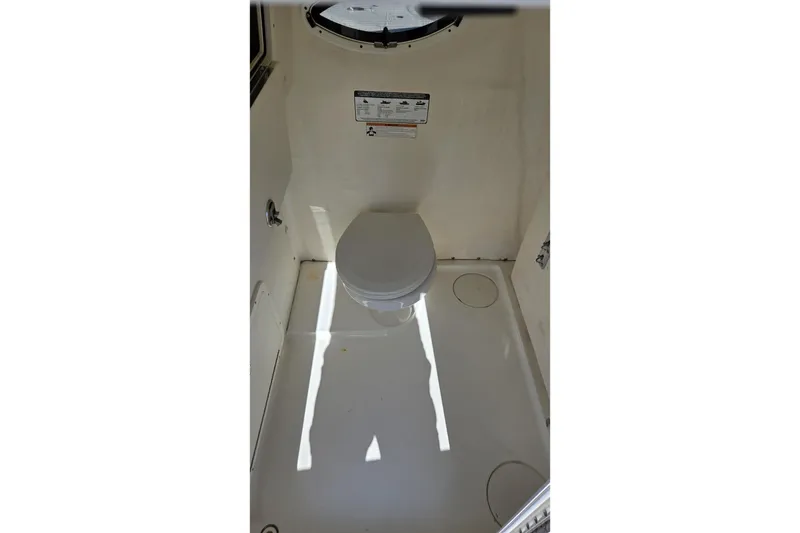 Slide: The Image of Interior view of 2019 World Cat 295 CC boat's compact marine toilet. - 13