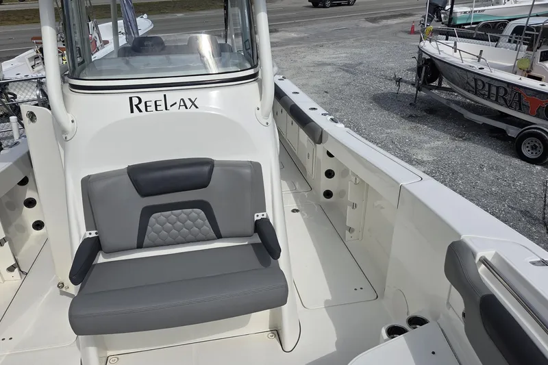 Slide: The Image of 2019 World Cat 295 CC boat interior with seating and "Reel-Ax" branding. - 16