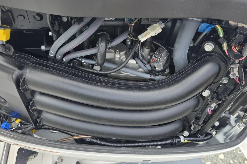 Slide: The Image of Engine components of a 2019 World Cat 295 CC boat, showcasing intricate wiring and tubing. - 31