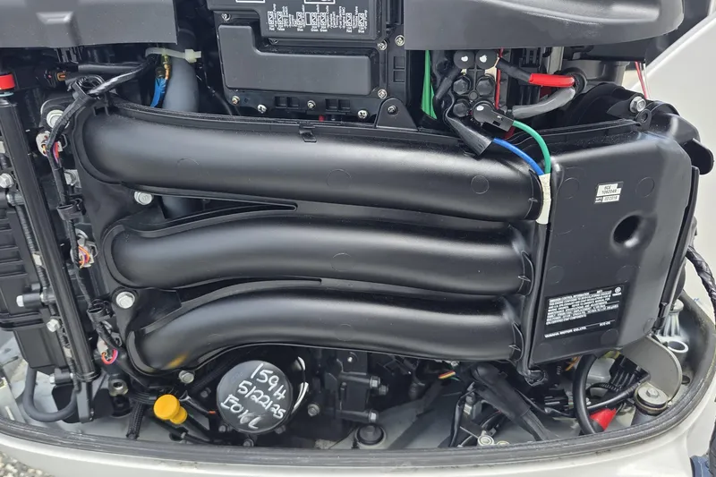 Slide: The Image of Close-up of a 2019 World Cat 295 CC boat engine, showcasing intricate components and wiring. - 32