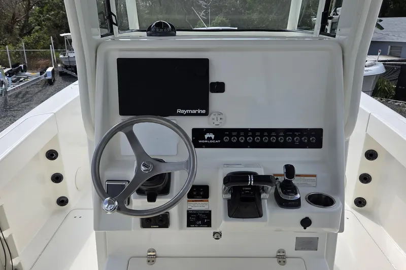 Slide: The Image of 2019 World Cat 295 CC boat dashboard with steering wheel and control panel. - 8