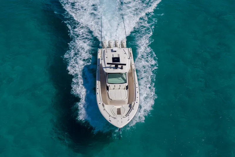 Slide: The Image of 2025 Grady-White Canyon 456 boat cruising on clear turquoise water. - 12