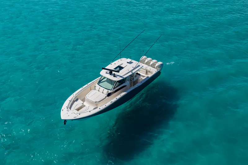 Slide: The Image of 2025 Grady-White Canyon 456 boat cruising on clear turquoise waters. - 2