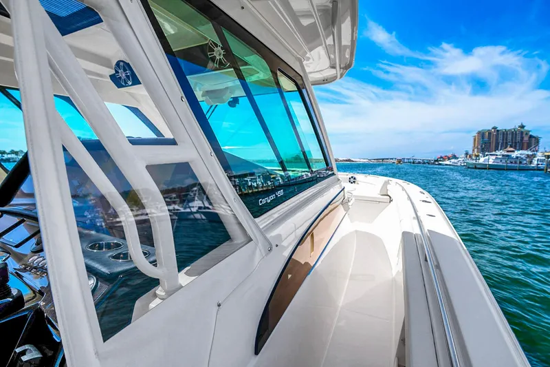 Slide: The Image of 2025 Grady-White Canyon 456 boat cruising on a sunny day near a marina. - 22