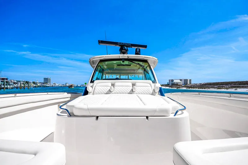 Slide: The Image of 2025 Grady-White Canyon 456 boat on water, clear blue sky background. - 23