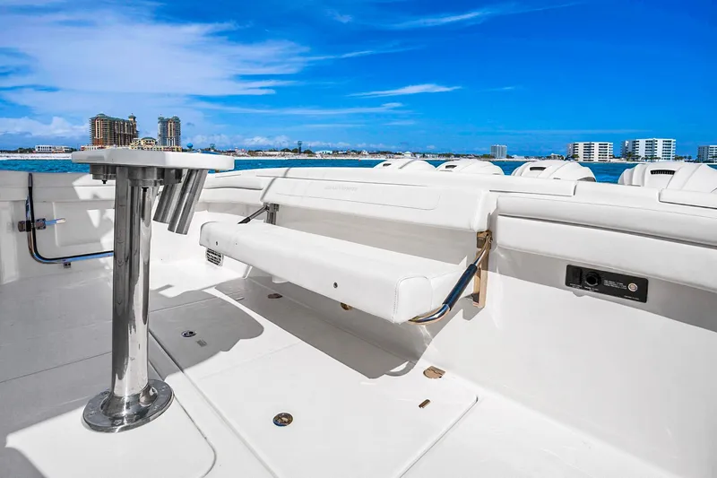 Slide: The Image of 2025 Grady-White Canyon 456 boat interior with rod holders, white seating, and ocean view. - 34