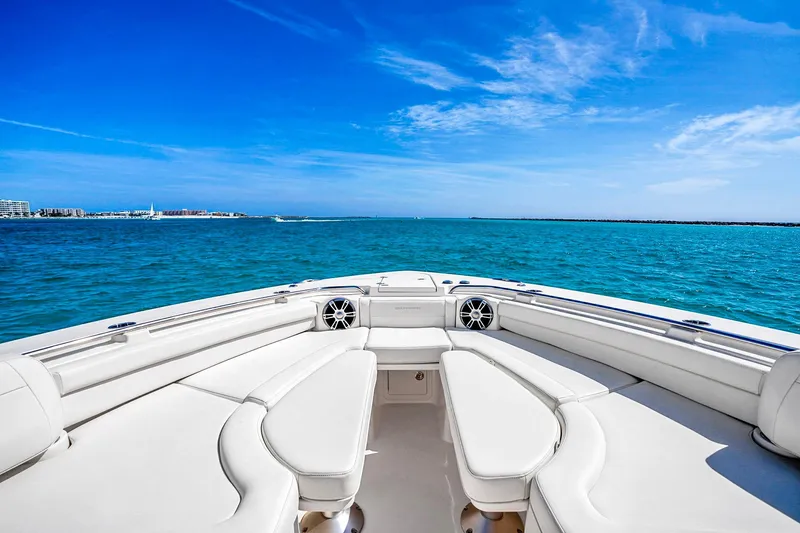 Slide: The Image of 2025 Grady-White Canyon 456 boat on open sea, featuring spacious seating and clear blue skies. - 38