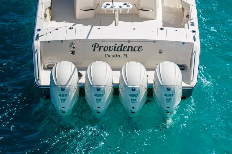 Slide: The Image of 2025 Grady-White Canyon 456 boat with four powerful outboard engines in turquoise water. - 4