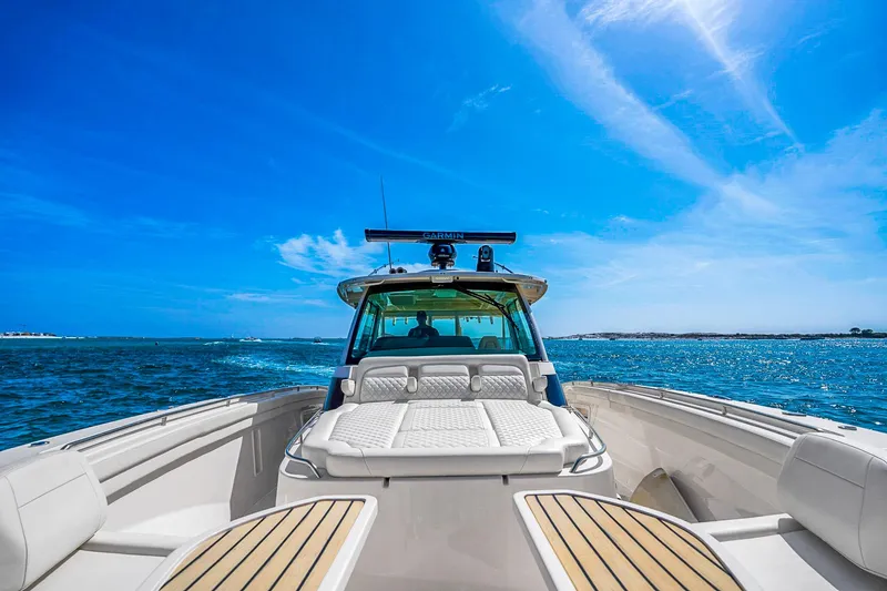 Slide: The Image of 2025 Grady-White Canyon 456 boat cruising on open water under clear blue skies. - 42