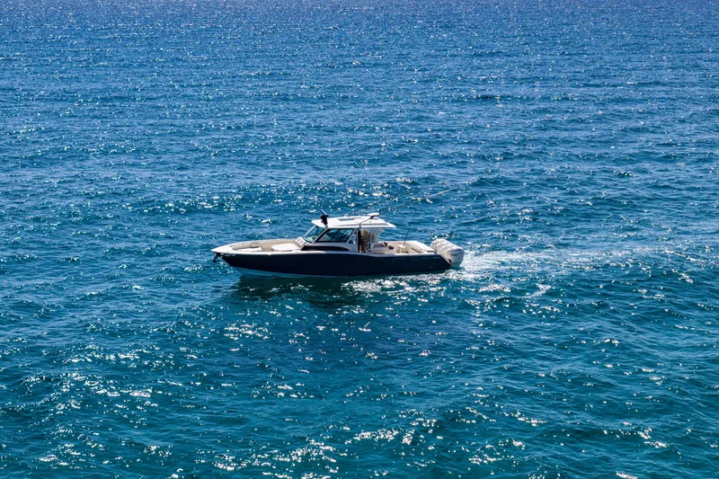 Slide: The Image of 2025 Grady-White Canyon 456 boat cruising on sparkling blue ocean waters. - 5