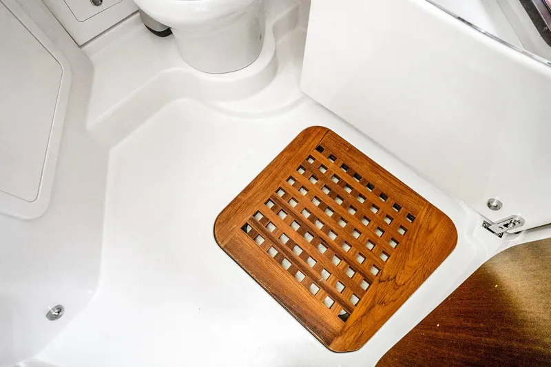 Slide: The Image of 2025 Grady-White Canyon 456 boat interior with wooden floor grate and white fixtures. - 52