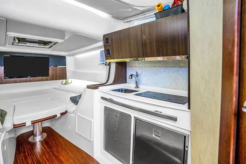 Slide: The Image of Luxurious interior of 2025 Grady-White Canyon 456 boat with modern kitchenette and seating area. - 57