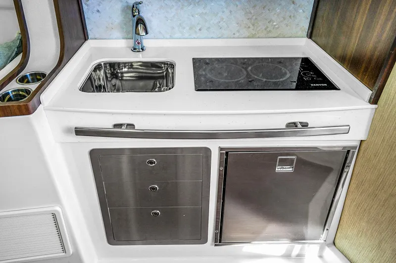 Slide: The Image of 2025 Grady-White Canyon 456 boat kitchen with sink, stove, and storage. - 60