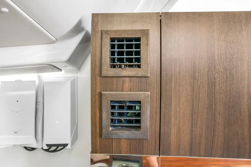 Slide: The Image of Interior of 2025 Grady-White Canyon 456 with wooden cabinetry and ventilation grilles. - 61