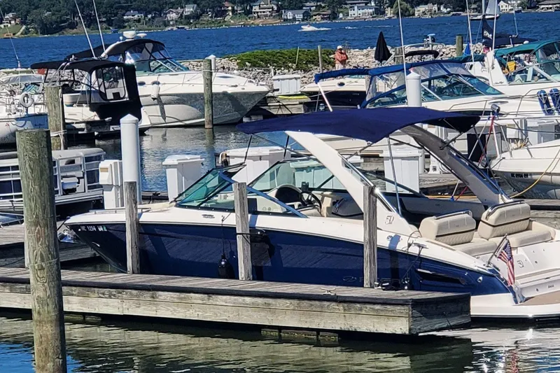 Slide: The Image of 2021 Regal 2800 Bowrider docked at a marina with other boats. - 2