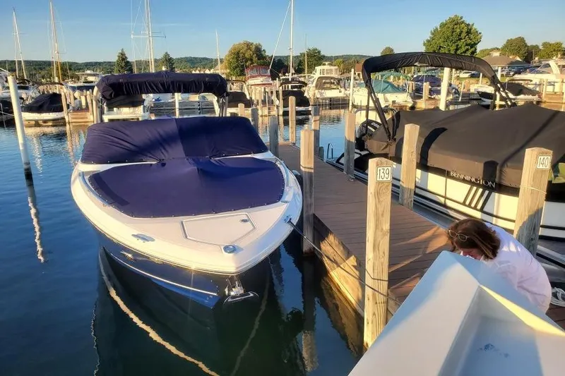 Slide: The Image of 2021 Regal 2800 Bowrider docked at marina with blue cover. - 5