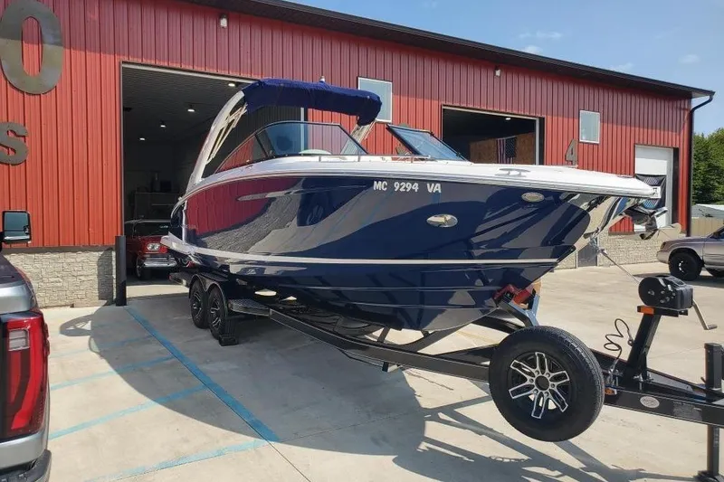 Slide: The Image of 2021 Regal 2800 Bowrider boat on trailer outside red building. - 7