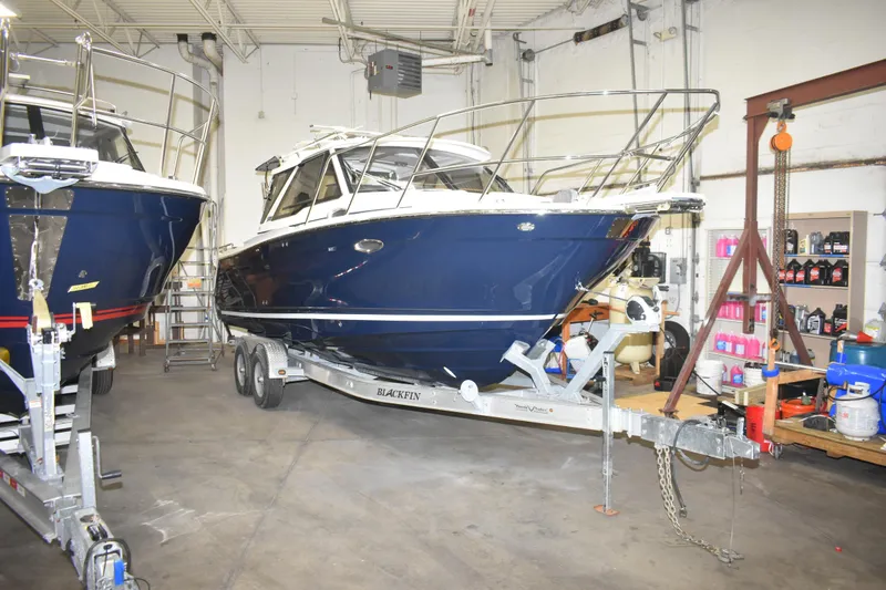 The Image of 2026 Cutwater C-248 Coupe boat on trailer in indoor storage facility. - 1