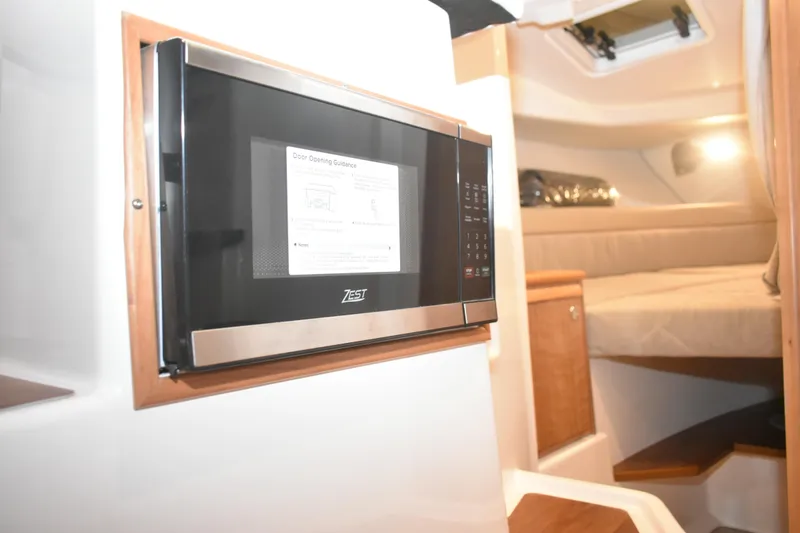 Slide: The Image of 2026 Cutwater C-248 Coupe interior with microwave and cozy cabin bed. - 30