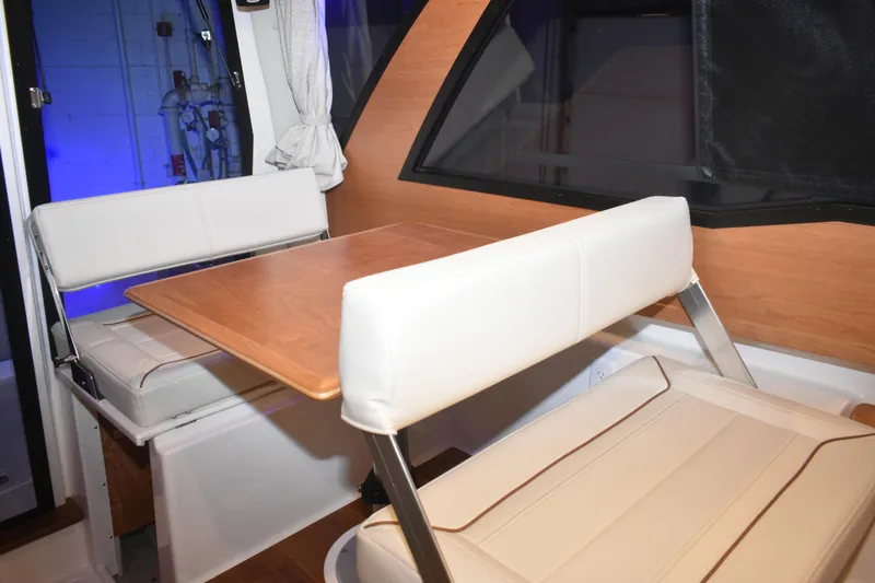 Slide: The Image of Interior of 2026 Cutwater C-248 Coupe featuring a cozy dining area with white seating. - 31