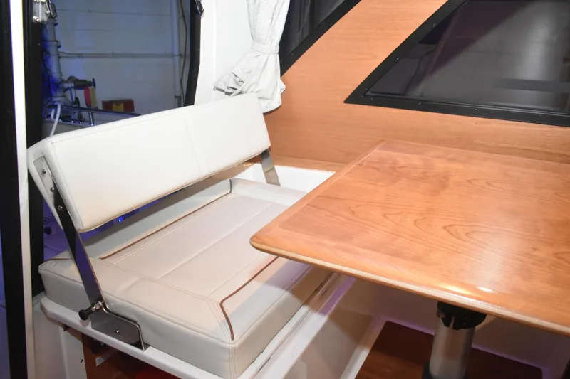 Slide: The Image of 2026 Cutwater C-248 Coupe interior with white seating and wooden table. - 33