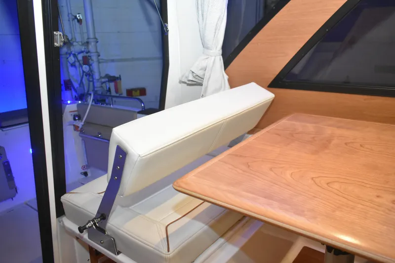 Slide: The Image of Interior of 2026 Cutwater C-248 Coupe featuring a wooden table and cushioned seating. - 35