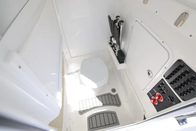 Slide: The Image of Interior of 2026 Sea Hunt Ultra 275 Coffin Box boat, featuring a compact bathroom setup. - 10