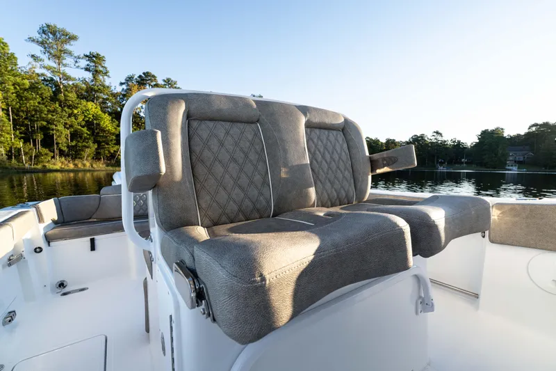 Slide: The Image of 2026 Sea Hunt Ultra 275 Coffin Box boat interior with cushioned seating, on a serene lake. - 43