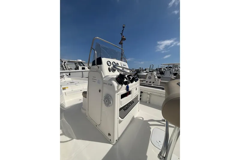 Slide: The Image of 2018 NauticStar 244 XTS boat console under clear blue sky. - 6