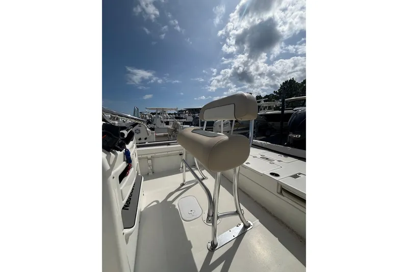 Slide: The Image of 2018 NauticStar 244 XTS boat interior with seating under a partly cloudy sky. - 7