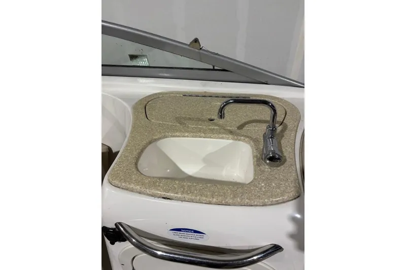 Slide: The Image of 2008 Chaparral 246 SSi boat sink with chrome faucet and beige countertop. - 14