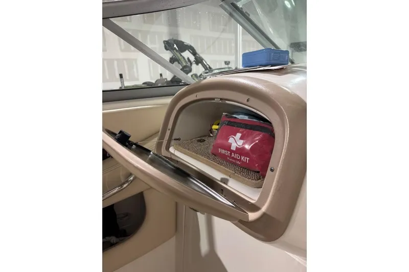 Slide: The Image of 2008 Chaparral 246 SSi boat dashboard with first aid kit in storage compartment. - 20