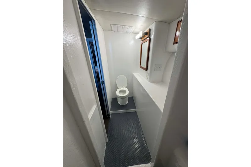 Slide: The Image of Compact bathroom interior of 1992 Blackwell Custom Carolina boat, featuring toilet and mirror. - 7