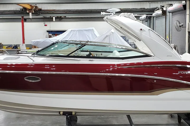 The Image of 2012 Formula 310 Sun Sport boat in a showroom, featuring sleek red and white design. - 0