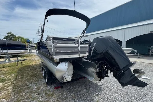 Slide: The Image of 2026 Barletta ARIA 22UC pontoon boat with Mercury outboard motor, parked on gravel. - 7