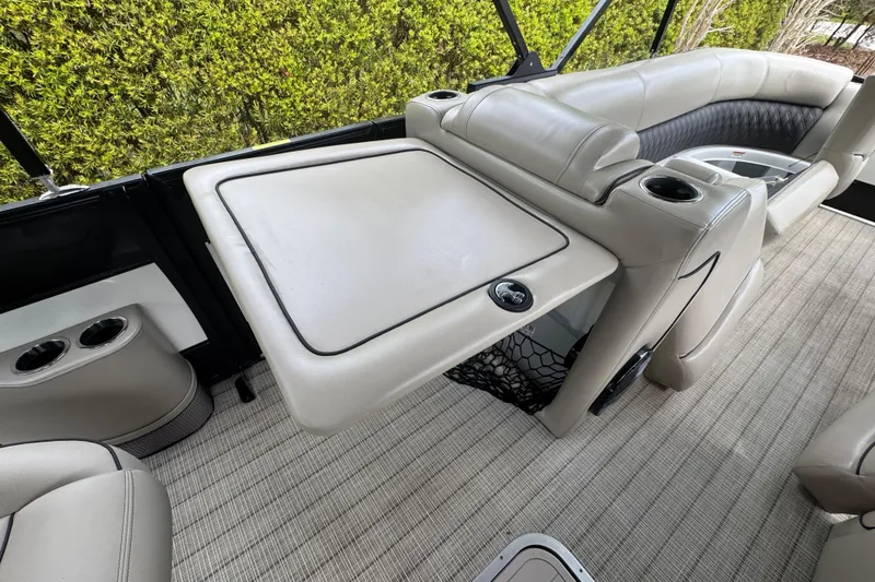 Slide: The Image of 2019 Barletta L25UCL pontoon boat interior with beige seating and table. - 16