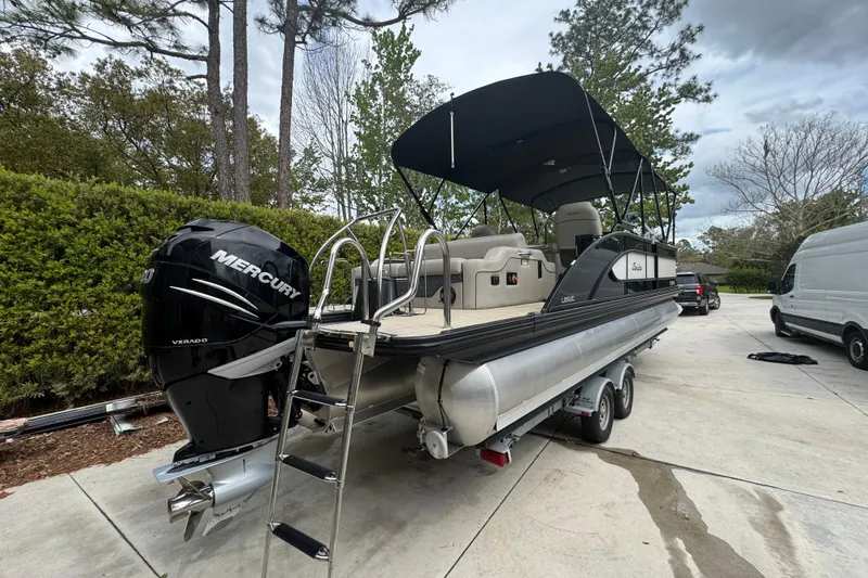 Slide: The Image of 2019 Barletta L25UCL pontoon boat with Mercury Verado engine on a trailer. - 2