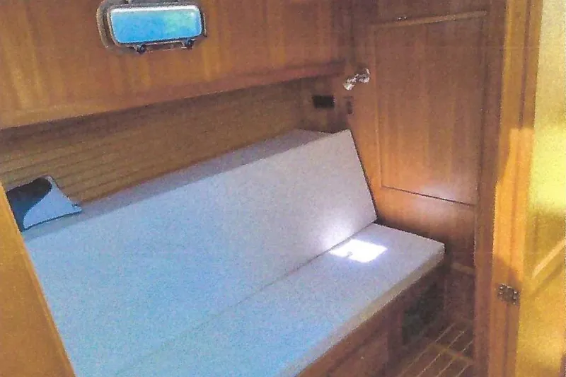 Slide: The Image of 2004 Sabre 42 Fly Bridge interior cabin with wooden paneling and cushioned seating. - 12