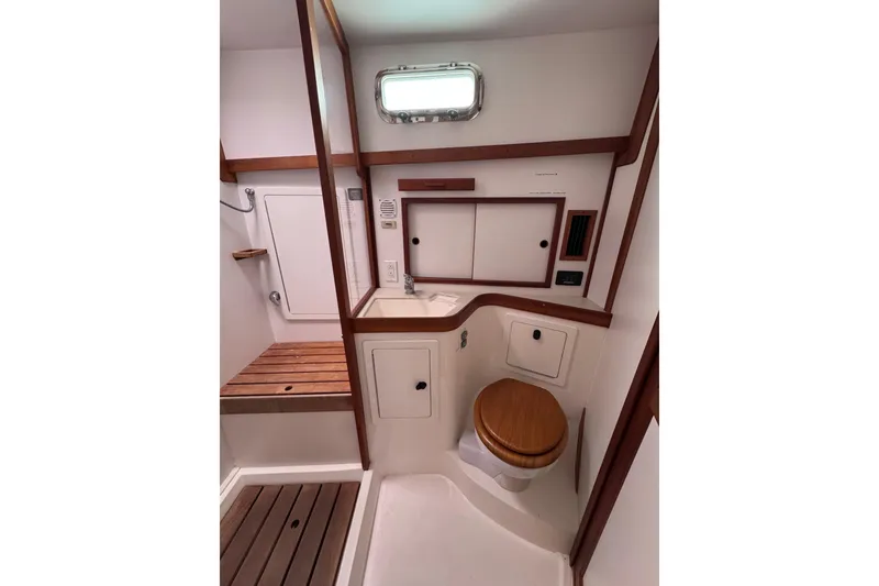 Slide: The Image of 2004 Sabre 42 Fly Bridge yacht bathroom with wooden accents and compact design. - 21