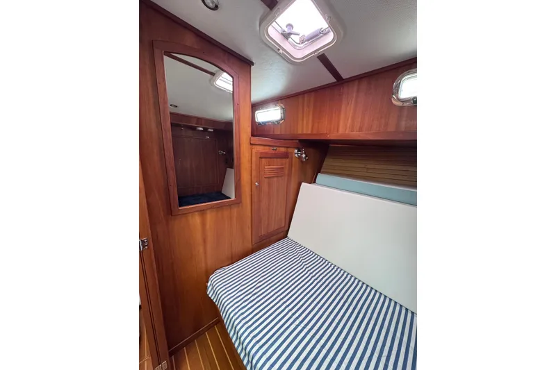 Slide: The Image of Cozy cabin interior of 2004 Sabre 42 Fly Bridge with striped bedding and wooden finish. - 23
