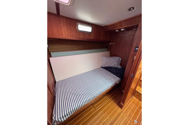 Slide: The Image of Cozy cabin interior of 2004 Sabre 42 Fly Bridge with striped bedding and wooden finish. - 24
