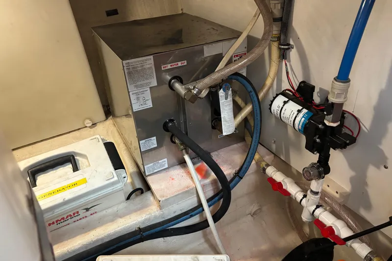 Slide: The Image of Engine room of 2004 Sabre 42 Fly Bridge with generator and plumbing components. - 28